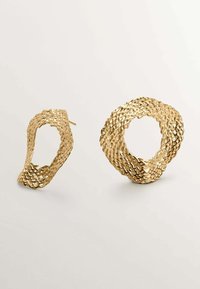 Pendientes de metal dorado con un diseño texturizado y ondulado. Un pendiente tiene forma de bucle retorcido, mientras que el otro es de forma circular abierta.