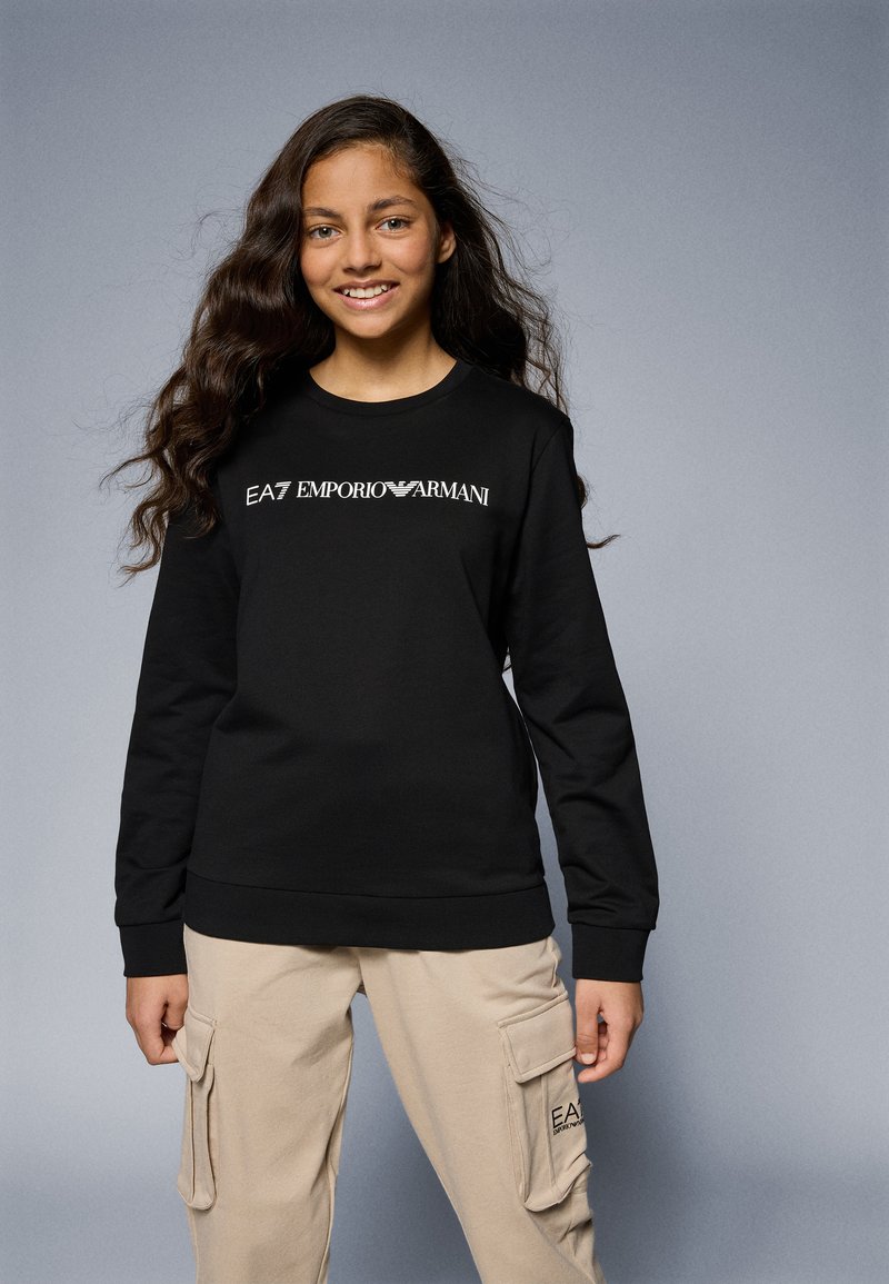 Sudadera negra con cuello redondo y mangas largas, que presenta un logotipo blanco de EA7 Emporio Armani en el pecho. Tela suave, corte relajado.