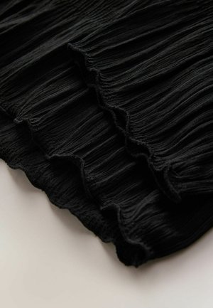 Black pleated fabric with textured surface and scalloped edges, showcasing soft draping and a consistent pattern throughout.