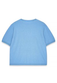 Īsām piedurknēm, brīvas piegriezuma džemperis gaiši zilā mīkstā adījumā. Iezīmējas ar ribinātu apkakli un apakšmalu, gludu tekstūru ar minimālu dekoru.