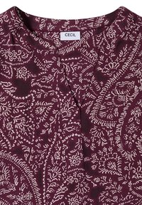 Blouse marron avec des motifs floraux et cachemire blancs complexes, encolure ronde avec une petite fente en V et étiquette de la marque CECIL à l'intérieur du col.