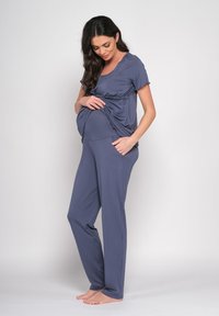 Maternity-Loungewear-Set aus weichem, grauem Stoff. Das Oberteil hat ein gerafftes Frontdesign; die Hose ist gerade geschnitten und hat eine lockere Passform.