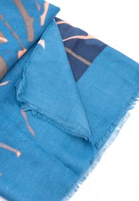 Blå mønstret tørklæde lavet af blødt stof, med frynset kanter og abstrakte designs i nuancer af blå, fersken og grå.