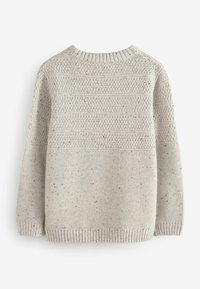 Pull en maille beige clair avec un col rond, présentant des motifs texturés et des détails légèrement chinés. Poignets et ourlet côtelés.