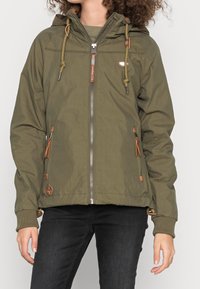 Olivově zelená bunda s kapucí, předním zipem a koženými akcenty. Obsahuje šňůrky, boční kapsy a žebrované manžety.