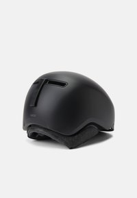 Černá cyklistická helma s hladkým, zaobleným designem. Má ventilační otvory, matný povrch a měkkou vnitřní podšívku pro pohodlí.