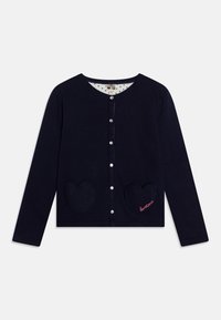 N�ámořnický cardigan s kapsami ve tvaru srdce, kulatým výstřihem a zapínáním na knoflíky. Vnitřní podšívka má jemný vzor teček.