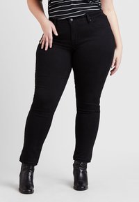 Svarte smale jeans laget av denim, med klassisk fem-lomme design, middels høyde livlinje, og en glatt, strukturert finish.