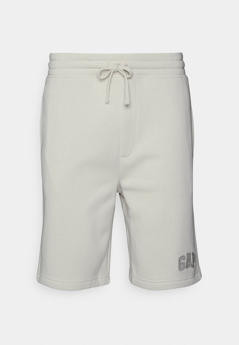 Shorts de survêtement couleur beige clair longueur genou avec taille à cordon de serrage et broderie discrète du logo "GAP" près de l'ourlet gauche.