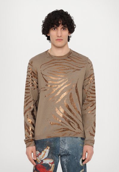 Beige langærmet sweater med bronze-mønster, der har et zebra-lignende design med glimmerdetaljer. Blød tekstur og tætsiddende design.