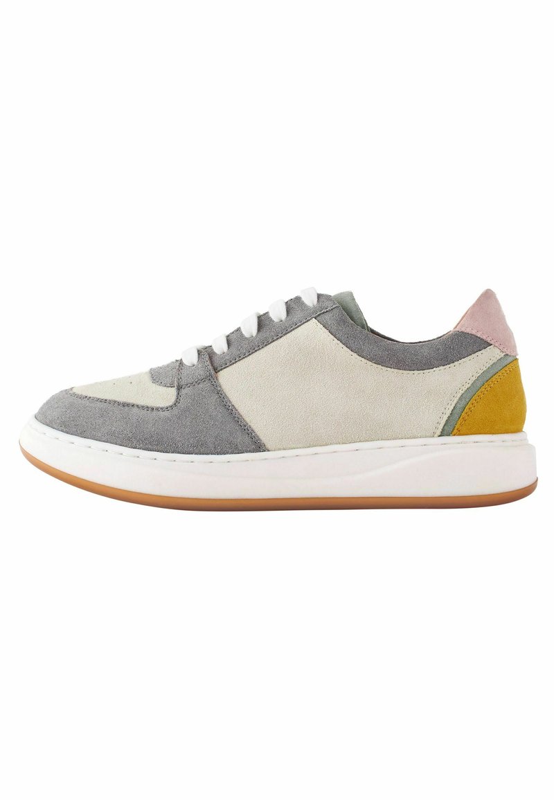 Mehrfarbiger Sneaker aus Wildleder und Leder, mit Grautönen, Creme, Grün, Pink und Gelb; flache Form, weiße Sohle.