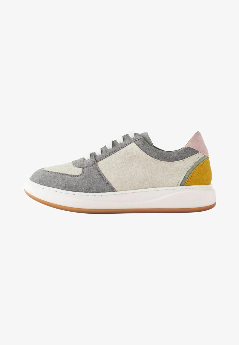 Mehrfarbiger Sneaker aus Wildleder und Leder, mit Grautönen, Creme, Grün, Pink und Gelb; flache Form, weiße Sohle.