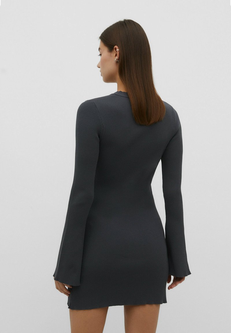 Rippierter, dunkelgrauer Langarmkleid mit figurbetontem Schnitt, ausgestellten Ärmelenden und einem rohen Saum am Boden.