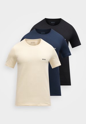 Drie effen BOSS T-shirts met ronde hals in beige, donkerblauw en zwart, gestapeld met zichtbare geborduurde logo's op de linkerborst.