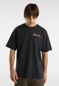 Černé bavlněné tričko s krátkým rukávem, na levé straně hrudi s zlatým logem "Vans". Uvolněný střih s kulatým výstřihem.