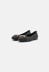 Ballerine nere con superiore in tessuto intrecciato, bordo in pelle e un accento in metallo dorato sulla punta. Design con suola piatta per il massimo comfort.