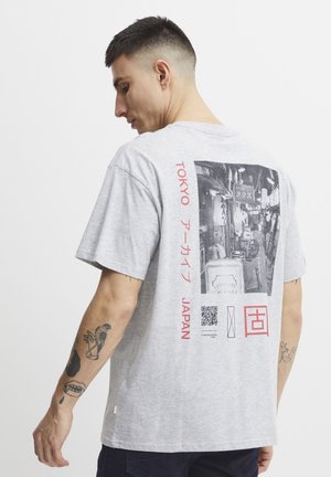 Gray short-sleeve t-shirt featuring a photographic print on the back, with red Japanese text and a QR code. Fabric appears cotton-based.