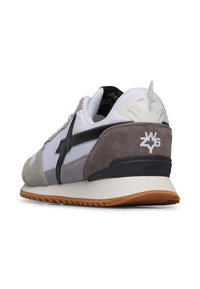 Sneaker con la parte superiore in suede grigio e rete bianca, accenti neri, suola in gomma testurizzata e un logo sul tallone. Include un tirante posteriore.