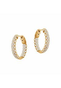 Złote kolczyki w kształcie obręczy z falistym wzorem, ozdobione przezroczystymi kryształkami, które dodają blasku i tekstury. Zapięcie na zawias u góry.