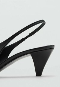Tacchi a slingback neri in pelle con tacco medio a blocco e punta affusolata, mostrati in primo piano in vista laterale su uno sfondo bianco.