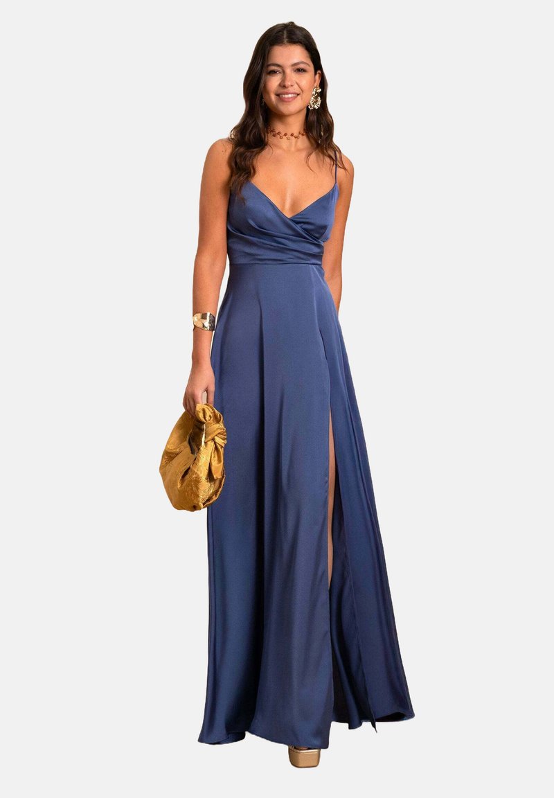 Lange, mouwloze, marineblauwe jurk met een wikkelontwerp en een zijsplit. Glad stof, vloerlengte, in combinatie met een gouden clutch.