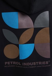 Zwarte hoodie met een geometrisch ontwerp met blauwe, donkergroene, bruine en grijze vormen. "PETROL INDUSTRIES" logo gedrukt aan de onderkant.