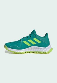 Baskets de sport turquoise avec des accents verts, tige texturée, semelle intermédiaire blanche et semelle extérieure en caoutchouc avec des motifs de traction.