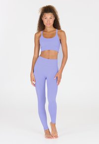 Lila Sport-BH und hochgeschnittene Leggings aus dehnbarem Stoff. Das Set zeichnet sich durch eine glatte Textur und eine figurbetonte Passform aus.
