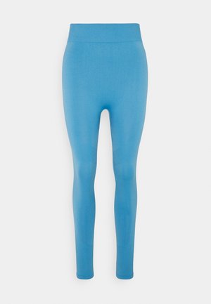 Leggings bleus avec une taille côtelée, texture lisse, coupe longue, sans motifs visibles ni détails matériels.