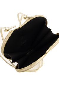Goldene Handtasche mit Reißverschluss, ausgestattet mit einem schwarzen Innenfutter. Das Design umfasst zwei knotete Griffe und eine glatte Textur.