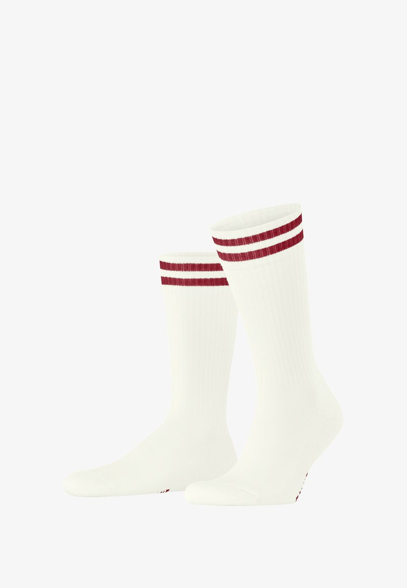Calzini bianchi con una texture a coste, caratterizzati da due strisce rosse orizzontali nella parte superiore. Forma tubolare standard con punta rinforzata.