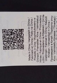 Etichetta con testo nero su sfondo bianco, che mostra più lingue. Include un codice QR in fondo. Il testo indica "Fabbricato in Cina."