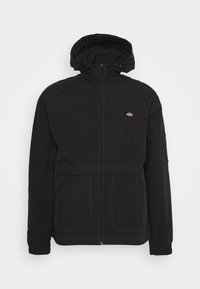 Svart huva jacka gjord av hållbart material, med en framsida dragkedja, tv å sidofickor och en broderad logotyp på vänster bröst.