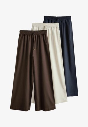 Drei Paare von Hosen mit weitem Bein, elastischem Bund und Kordelzug, in Braun, Beige und Dunkelblau, von links nach rechts geschichtet.
