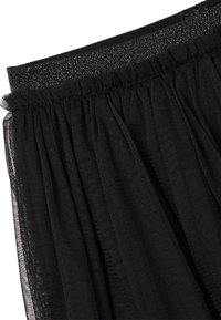 Schwarzer Tüllrock mit einem gerafften Taillenbund und einem glitzernden Akzent. Der Stoff ist leicht und durchscheinend, mit einer fließenden Textur.