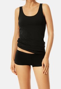 Débardeur noir avec un décolleté rond et un design sans manches, associé à un shorty noir. Le tissu semble lisse et extensible.
