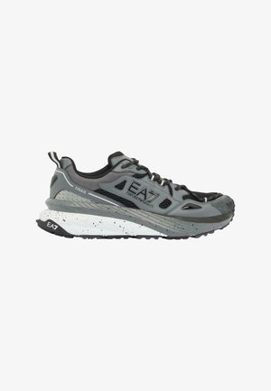 Zapatilla de trail running gris y negra con suela blanca moteada y logo EA7 Emporio Armani en el lateral derecho.