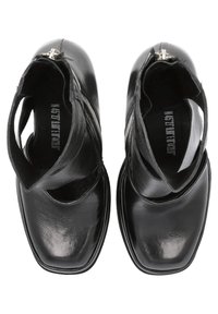 Black ankle boots made of leather with a smooth texture, featuring cut-out sides, a square toe, and a zipper detail on the back.