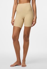 Beige shorts med hög midja, tillverkade av ett mjukt, elastiskt material, som sträcker sig till mitten av låret med en sömlös design.