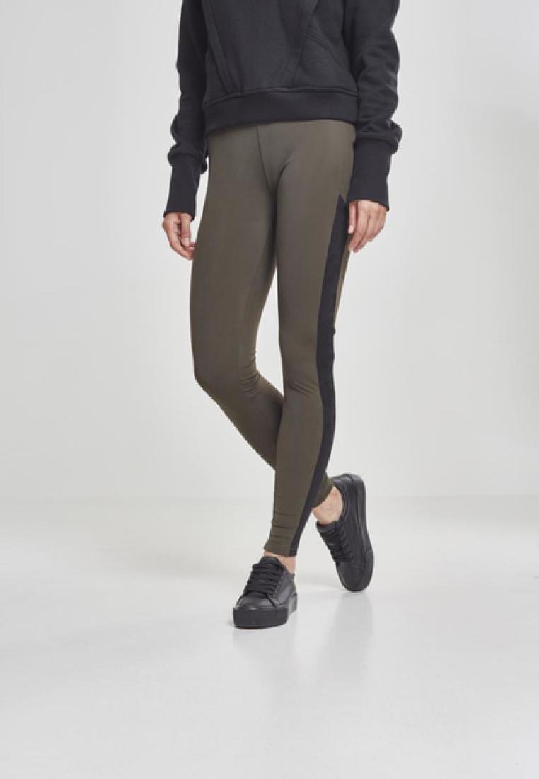 Alyvuogių spalvos leggingai su juodais šoniniais intarpais, pagaminti iš tamprios medžiagos patogumui. Dėvimi su juodu megztiniu ir juodais sportbačiais.