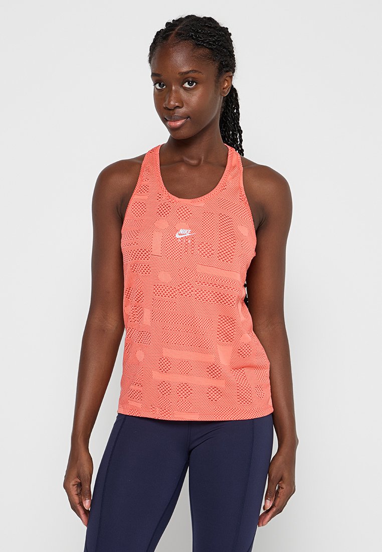 Nike Damen Tanktop in leuchtendem Korallenrot mit einem atmungsaktiven Mesh-Design. Mit einem Logo auf der Brust und einem Racerback-Style.