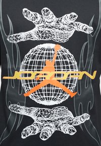  Μαύρο μπλουζάκι με γεωμετρικό σχέδιο σύρματος που απεικονίζει χέρια και μια γη, με πορτοκαλί σιλουέτα παίκτη μπάσκετ και το κείμενο "JORDAN".