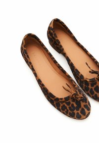Ballerines en imprimé léopard avec une texture douce en daim, bouts ronds et un petit nœud à l'avant. Présentent également une semelle intérieure beige.