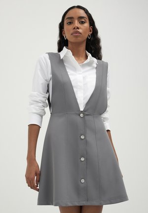 Robe grise en A avec un décolleté en V profond, sans manches, et six boutons fleuris sur le devant. Le tissu semble lisse et bien structuré.