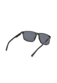 Czarne plastikowe okulary przeciwsłoneczne z ciemnymi soczewkami, prostokątnym kształtem, teksturowanymi czarnymi ramionami i matowym wykończeniem. Charakteryzują się minimalnymi akcentami sprzętowymi.