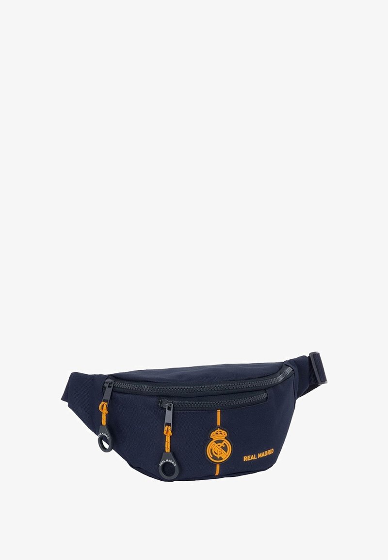 Banane marine en tissu résistant, dotée d'une poche avant zippée, d'accents orange et d'un logo du Real Madrid. Sangle ajustable incluse.