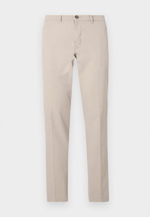 Beige, smalle bukser med bæltestropper, knaplukning og frontlynlås, vist fladt mod en hvid baggrund.