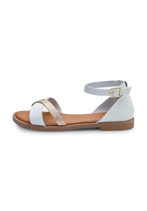 Sandal en cuir blanc avec une sangle diagonale texturée dorée, une sangle à la cheville avec une boucle dorée et une semelle marron. Conception plate et ouverte à l'avant.