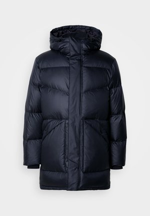 Marineblå pufferjakke med hette, frontlommeklaff og to store sidelommer. Stoffet har en glatt, blank tekstur med diagonale sømmer.