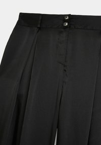 Pantaloni neri realizzati in un tessuto liscio, con una vita piatta, due bottoni e pieghe nette sul davanti, che evidenziano un design elegante.